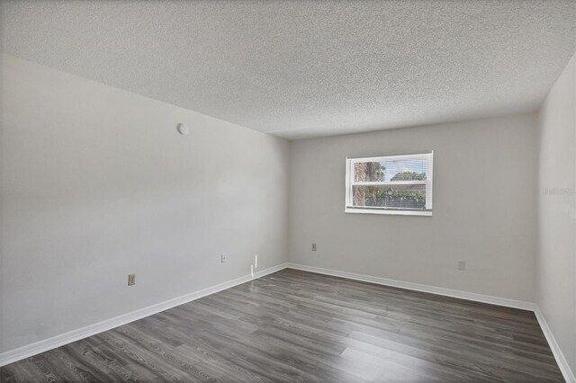 5800 Hollywood Blvd Unit 312, Sarasota, FL 34231 - spare room featuring a textured ceiling, baseboards, and dark wood-style floors
