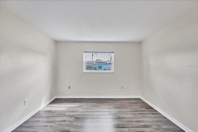 5800 Hollywood Blvd Unit 312, Sarasota, FL 34231 - spare room with a textured ceiling, baseboards, and wood finished floors
