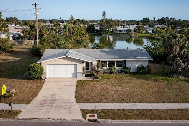 single story home with a front yard, a garage, a residential view, a water view, and concrete driveway