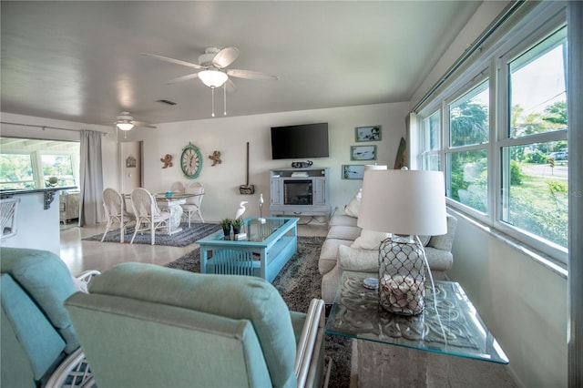 living area featuring a healthy amount of sunlight, ceiling fan, and visible vents