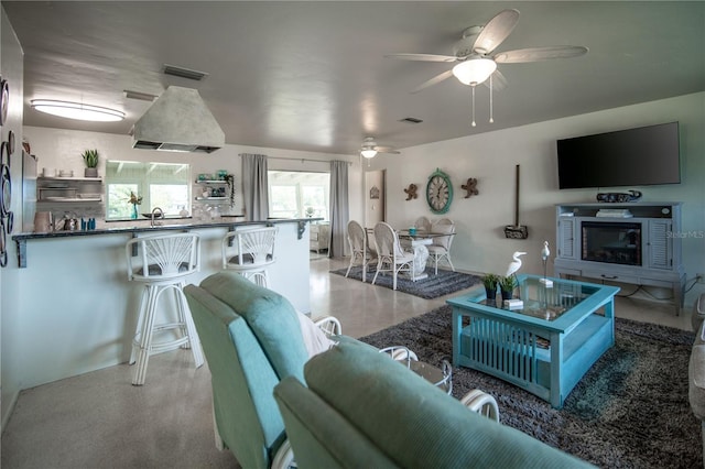 living area featuring ceiling fan and visible vents