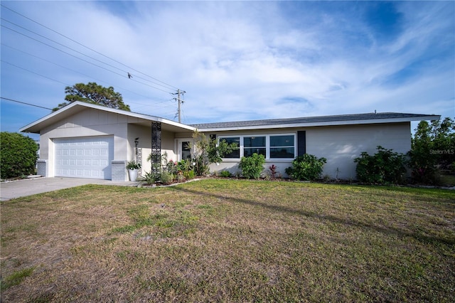single story home featuring concrete driveway, a front lawn, and an attached garage