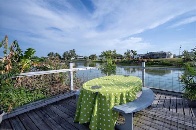 deck featuring outdoor dining area and a water view