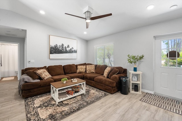 living area featuring a ceiling fan, vaulted ceiling, a healthy amount of sunlight, and light wood-type flooring