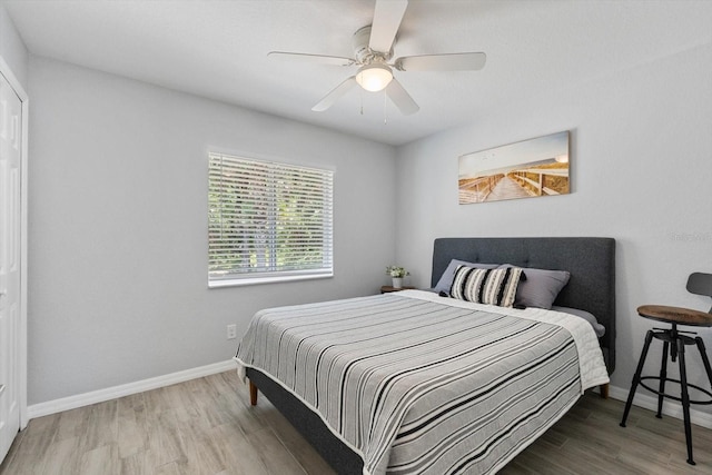 bedroom with baseboards, ceiling fan, and wood finished floors
