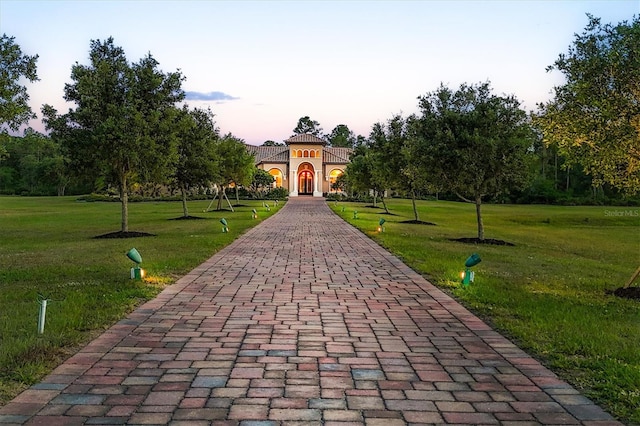 view of community with a lawn and decorative driveway