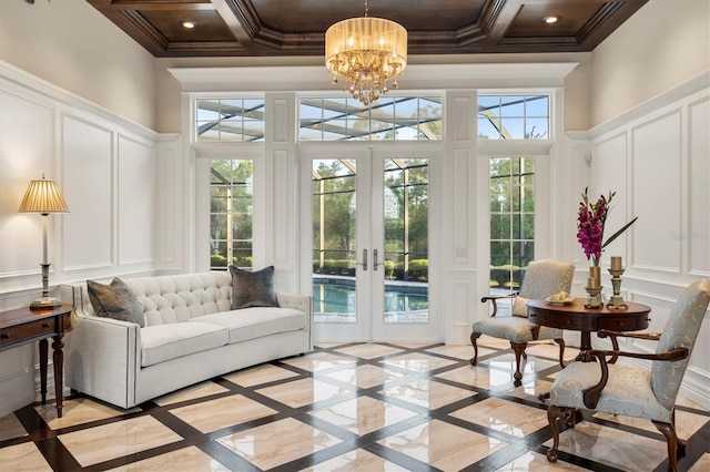 sunroom / solarium featuring an inviting chandelier, coffered ceiling, and french doors