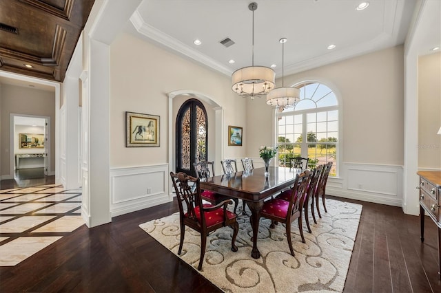 dining area with an inviting chandelier, wainscoting, arched walkways, visible vents, and dark wood-style floors