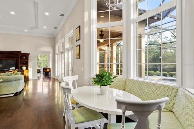 dining space featuring crown molding, a wealth of natural light, hardwood / wood-style floors, and visible vents