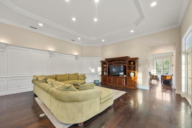 living room with visible vents, a tray ceiling, a decorative wall, and dark wood-style floors