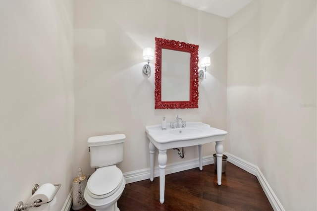bathroom with baseboards, toilet, and wood finished floors