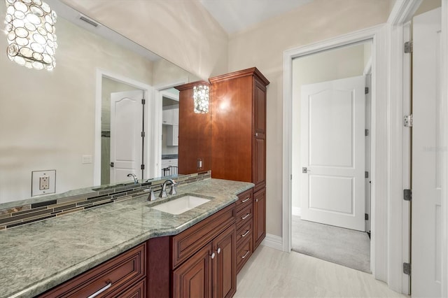 bathroom with vanity, baseboards, and visible vents