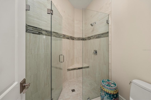 full bath featuring a stall shower and toilet