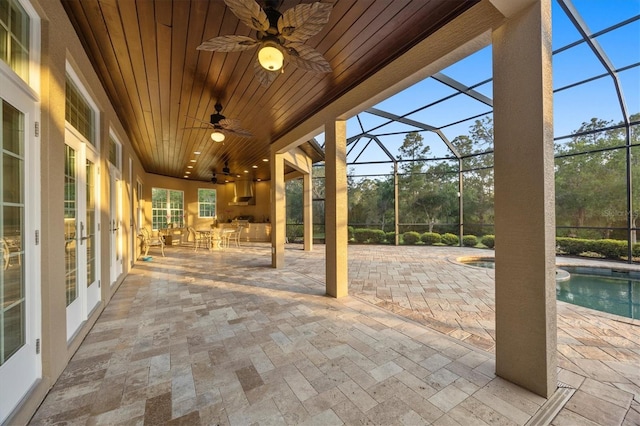 view of patio / terrace with french doors, a ceiling fan, glass enclosure, and an outdoor pool