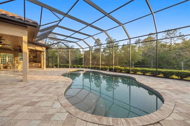 outdoor pool featuring a lanai, a patio, and a ceiling fan