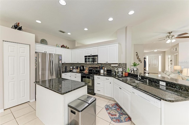 6546 Blue Grosbeak Cir, Lakewood Ranch, FL 34202 - kitchen with appliances with stainless steel finishes, a sink, a peninsula, light tile patterned flooring, and decorative backsplash