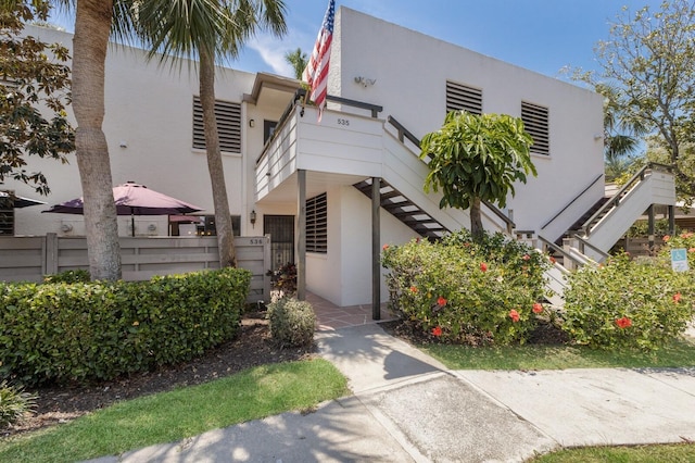 536 Lakeside Dr Unit 0, Bradenton, FL 34210 - view of front of house with stairway, stucco siding, and fence
