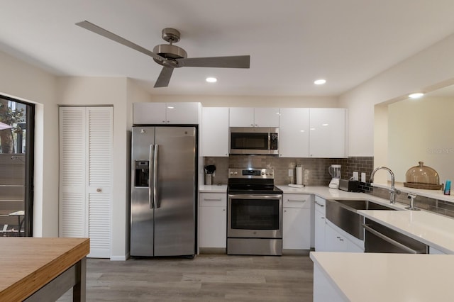 536 Lakeside Dr Unit 0, Bradenton, FL 34210 - kitchen featuring stainless steel appliances, a sink, light wood finished floors, white cabinets, and recessed lighting
