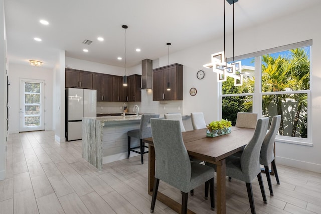 dining room with recessed lighting, light wood-style floors, baseboards, visible vents, and a notable chandelier