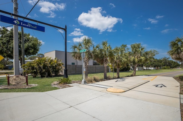 view of sport court with fence and a lawn