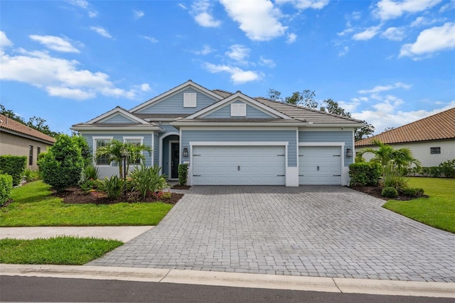 13319 Deep Blue Pl, Bradenton, FL 34211 - view of front of house with decorative driveway, an attached garage, a front lawn, and a tile roof