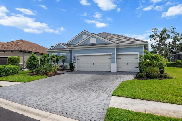 13319 Deep Blue Pl, Bradenton, FL 34211 - ranch-style house with decorative driveway, an attached garage, a front yard, and a tile roof