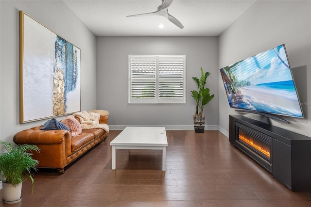 13319 Deep Blue Pl, Bradenton, FL 34211 - living room with ceiling fan, a glass covered fireplace, dark wood-style floors, and baseboards
