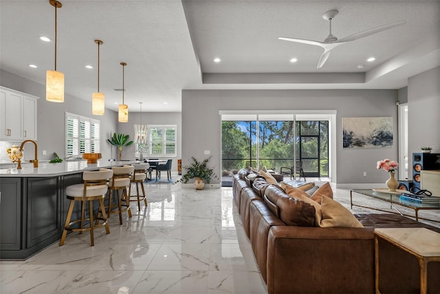 13319 Deep Blue Pl, Bradenton, FL 34211 - living area with a ceiling fan, recessed lighting, light marble finish floors, and a raised ceiling