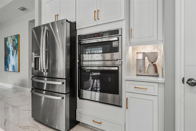 13319 Deep Blue Pl, Bradenton, FL 34211 - kitchen with appliances with stainless steel finishes, light marble finish floors, light countertops, baseboards, and white cabinets