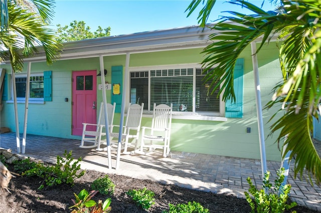 205 Elm Ave, Anna Maria, FL 34216 - doorway to property featuring a porch and concrete block siding