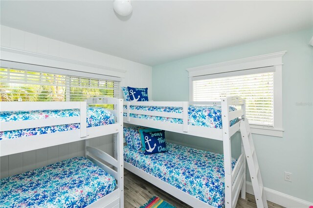 205 Elm Ave, Anna Maria, FL 34216 - bedroom featuring baseboards, wood finished floors, and multiple windows