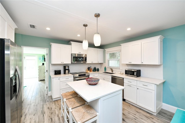 205 Elm Ave, Anna Maria, FL 34216 - kitchen with a sink, white cabinets, stainless steel appliances, and visible vents