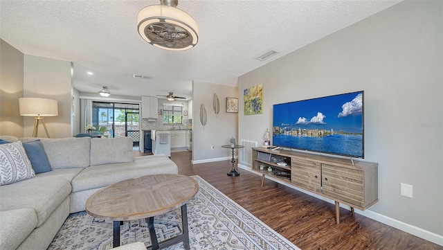 living area featuring baseboards, wood finished floors, and visible vents