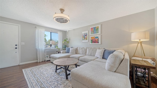 living area featuring baseboards, a textured ceiling, and wood finished floors