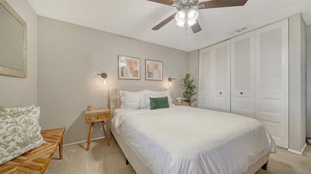 bedroom with light colored carpet, a ceiling fan, baseboards, visible vents, and a closet