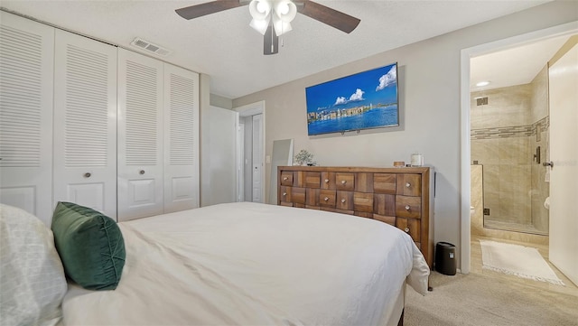 carpeted bedroom featuring visible vents, ceiling fan, a closet, and ensuite bathroom
