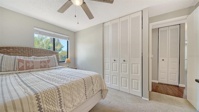 carpeted bedroom featuring a closet, a textured ceiling, and ceiling fan