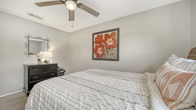 bedroom featuring ceiling fan, a textured ceiling, carpet, baseboards, and visible vents