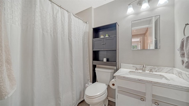 bathroom featuring vanity, toilet, and a textured ceiling