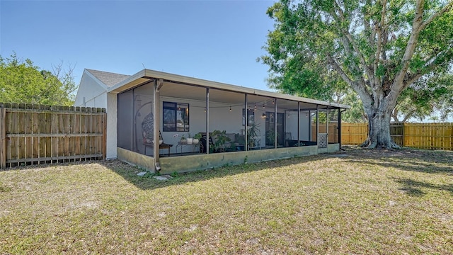 view of outbuilding with a fenced backyard and a sunroom