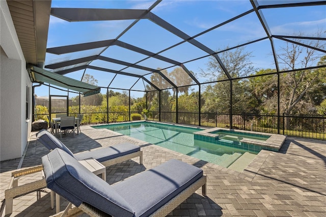 view of swimming pool featuring a patio, outdoor dining space, glass enclosure, and a pool with connected hot tub