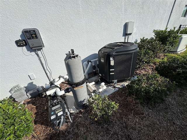 exterior details featuring stucco siding and cooling unit