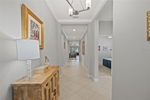 hall featuring light tile patterned floors, a notable chandelier, crown molding, visible vents, and baseboards