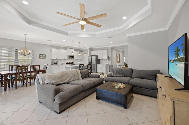 living room with recessed lighting, light tile patterned floors, ornamental molding, ceiling fan with notable chandelier, and a raised ceiling