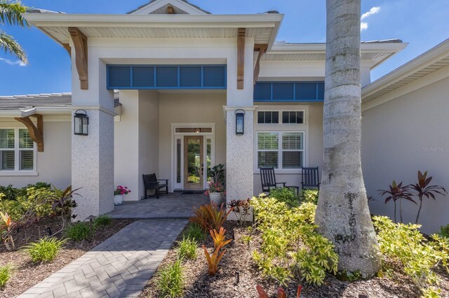 14210 9th Ter NE, Bradenton, FL 34212 - doorway to property featuring stucco siding and covered porch