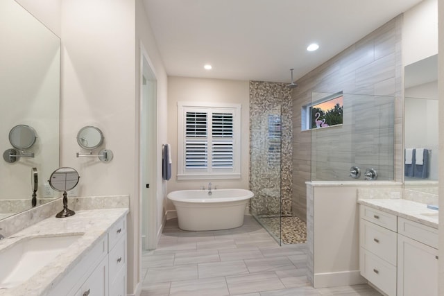 14210 9th Ter NE, Bradenton, FL 34212 - bathroom featuring a walk in shower, two vanities, a freestanding tub, and recessed lighting