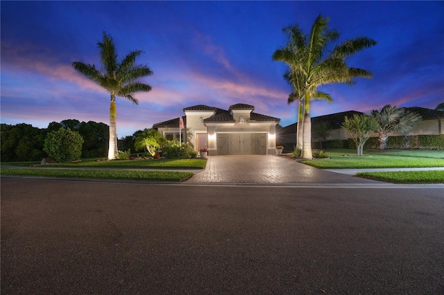 view of front of home featuring a garage, a front lawn, stucco siding, and driveway