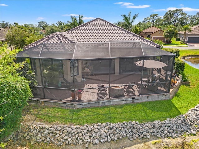 exterior space with glass enclosure, a tile roof, and a patio