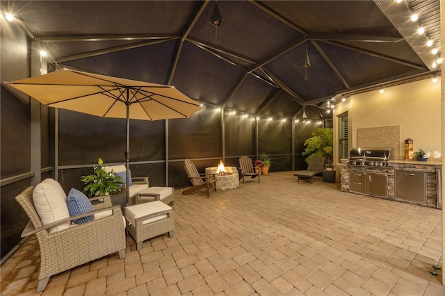 patio at twilight with a grill, a fire pit, a lanai, and area for grilling