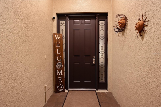 doorway to property featuring stucco siding